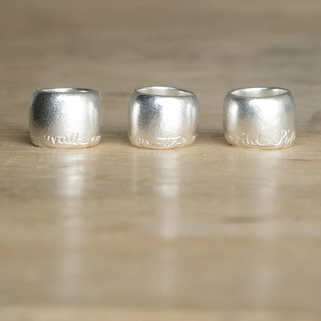 Walk on the Wild Side rings. Silver. 3 rings each turned to a position so the phrase Walk On The Wild Side can be read