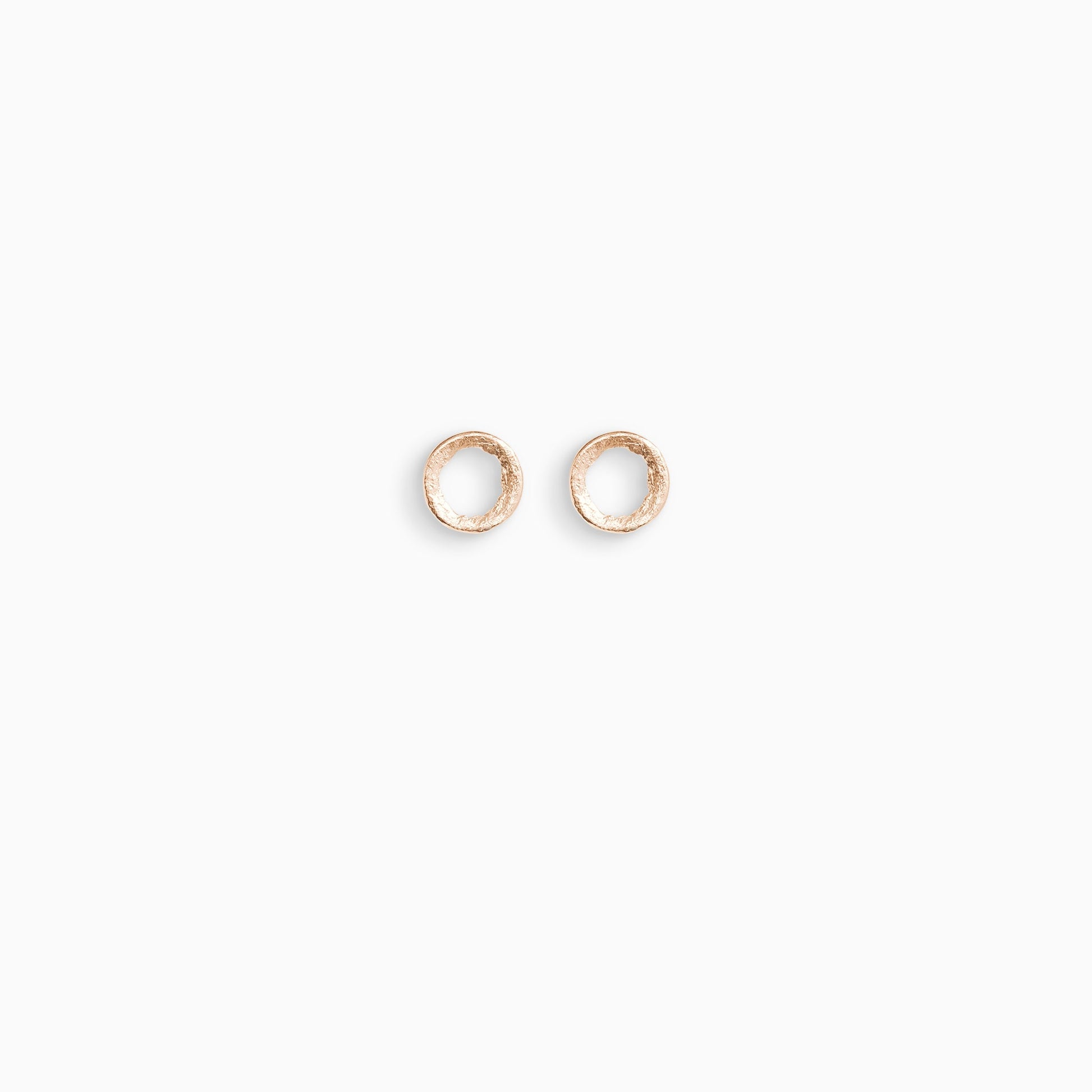 A pair of 18ct Fairtrade rose gold stud earrings, round in form with an open centre. Strong organic texture. Smooth outside edge, fragmented inside edges. 11mm outside diameter.
