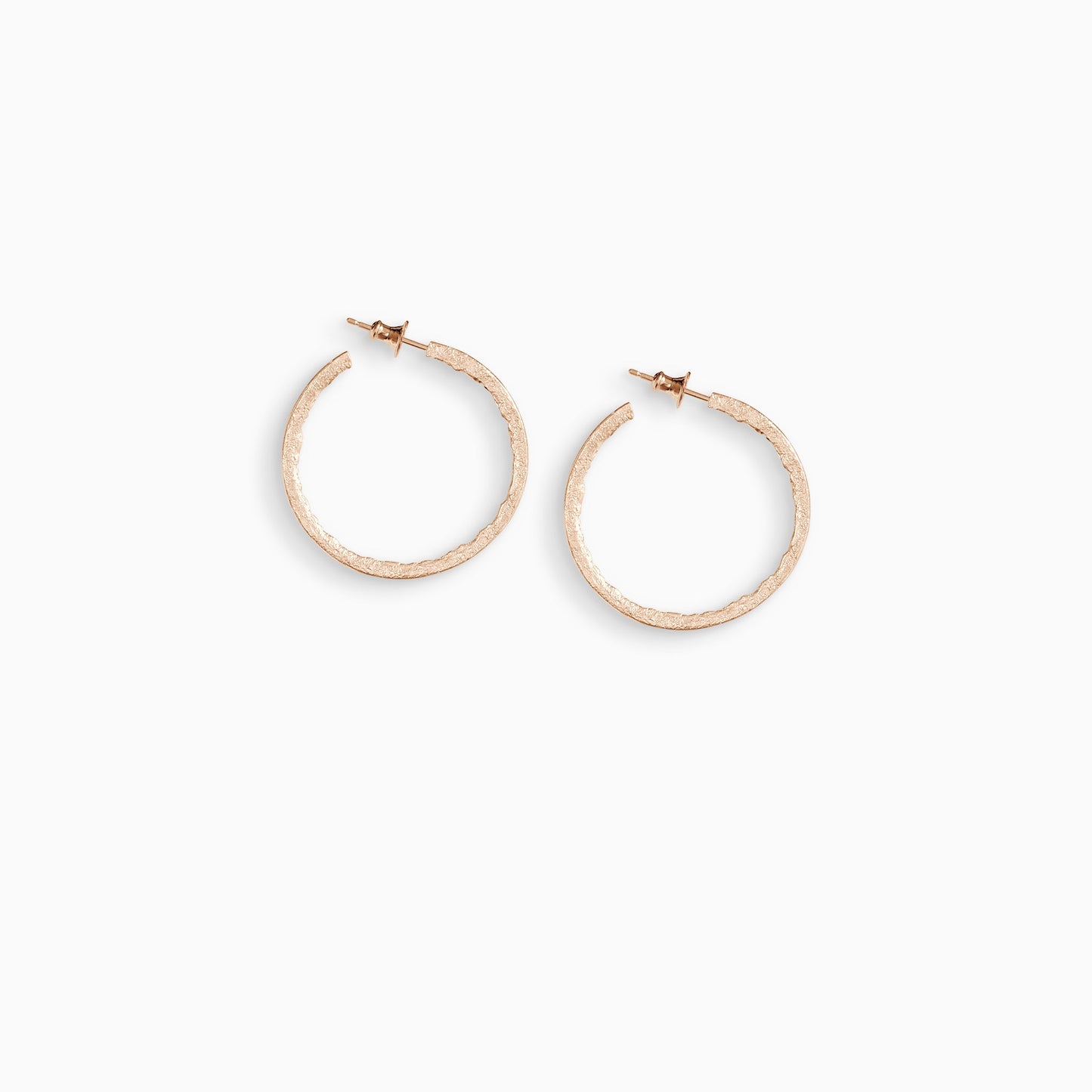 A pair of 18ct Fairtrade rose gold  round hoop earrings with a stud fastening. Smooth outside edge, fragmented inside edges. 36mm outside diameter.