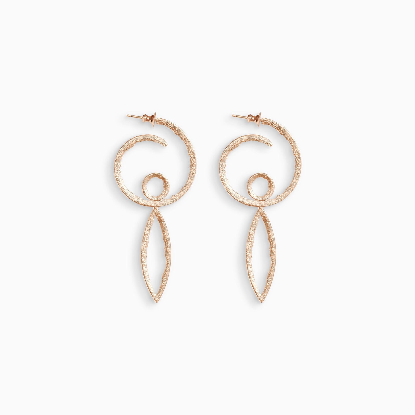 A pair of 18ct Fairtrade rose gold  hoop earrings in the form of a swirl with a stud ear fastening. Inside the bottom of the hoop is a small circle shape and below the hoop there is a long lozenge shape. These open shapes have a strong organic texture and are smooth on the outside edge with fragmented inside edges. 36mm outside diameter