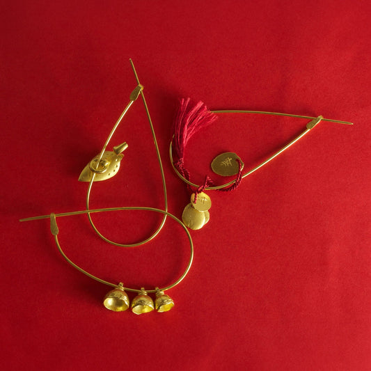 Wright & Teague Nuba pins. 18ct Fairtrade gold. Shown on a red background.