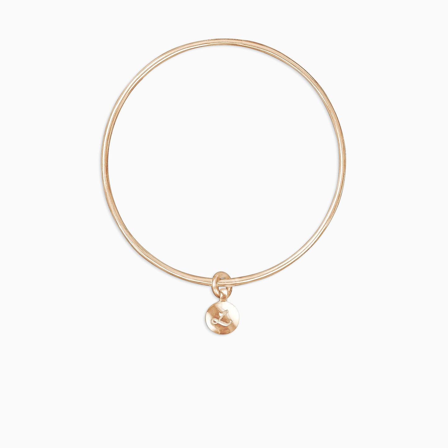 An 18ct Fairtrade rose gold round, smooth charm engraved with a single letter, choose from A-Z, freely moving on a round wire bangle. Charm 13mm diameter. Bangle 63mm inside diameter x 2mm round wire.