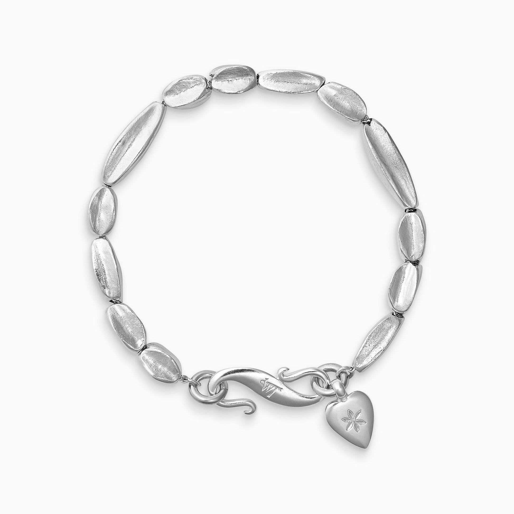 A recycled Silver bracelet of handmade organic, concave, square section textured ‘Baluba’ beads. Finished with a smooth heart shaped charm, engraved with a 6 petal flower and our signature ’S’ clasp.Bracelet length 210mm.. Beads varying lengths from 10mm to 40mm. Cross section of each bead approximately 6mm.