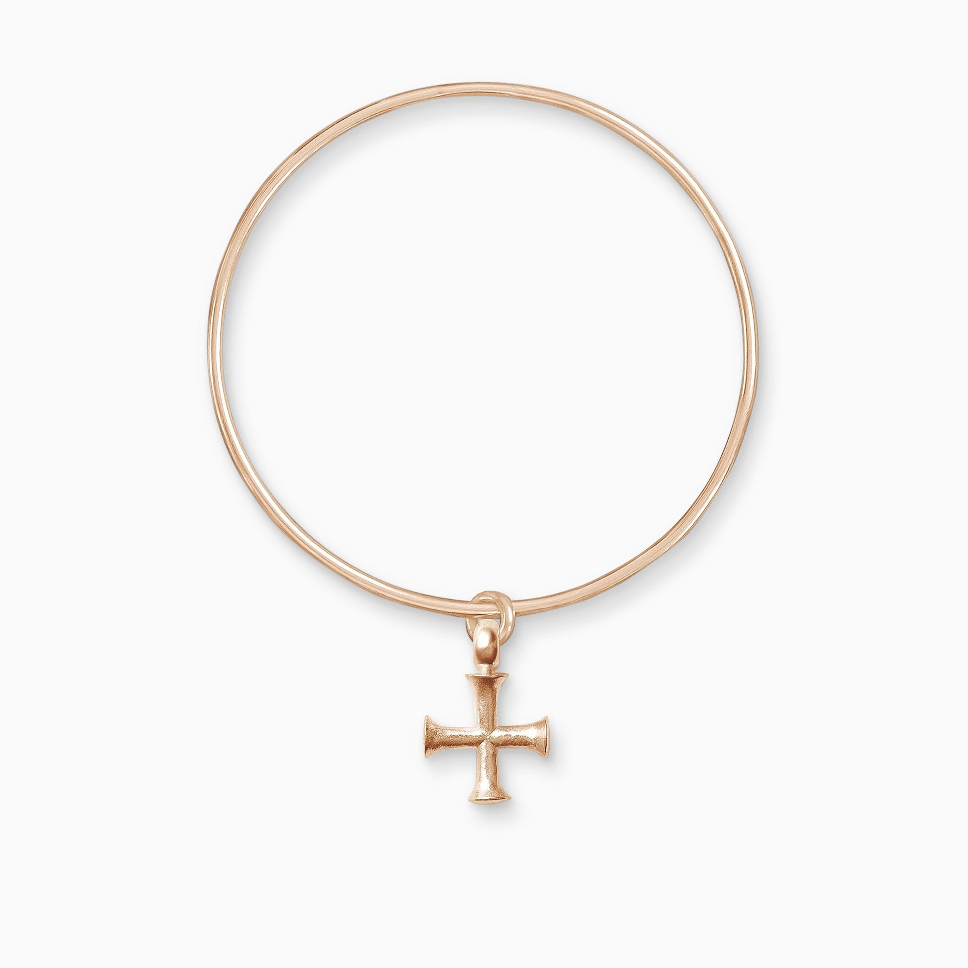 An 18ct Fairtrade rose gold geometric cross charm freely moving on a round wire bangle. The cross has equal length arms with outward spreading ends.  Charm 25mm. Bangle, 63mm inside diameter x 2mm round wire.