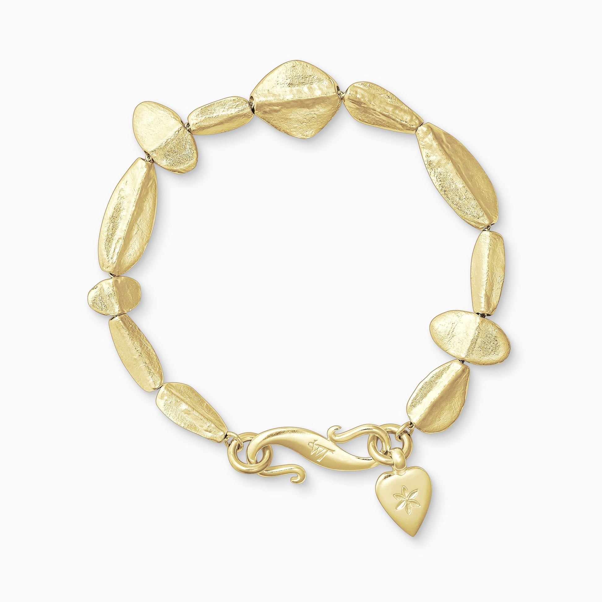 An 18ct Fairtrade yellow gold bracelet of handmade textured beads with a central ridge.  Finished with a smooth heart shaped charm engraved with a 6 petal flower and our signature ’S’ clasp. Bracelet length 210mm. Beads varying sizes from 11mm x 6mm to 35mm x 15mm.