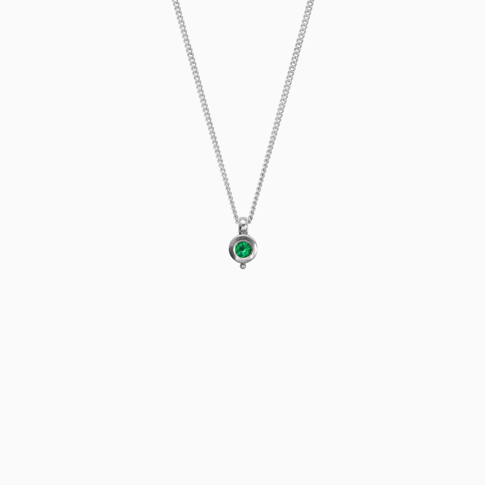 Recycled platinum round pendant 12mm  x 7mm with small round bead attached below on a 45cm fine curb chain. Set with a 4mm round emerald.