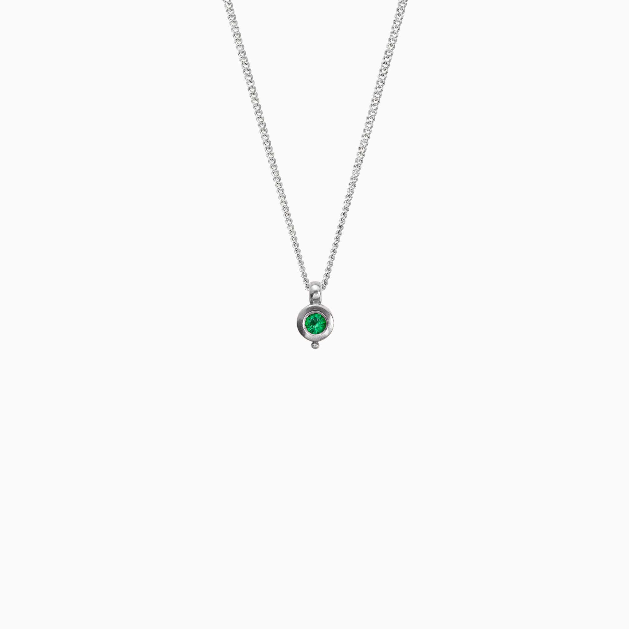 Recycled platinum round pendant 12mm  x 7mm with small round bead attached below on a 45cm fine curb chain. Set with a 4mm round emerald.