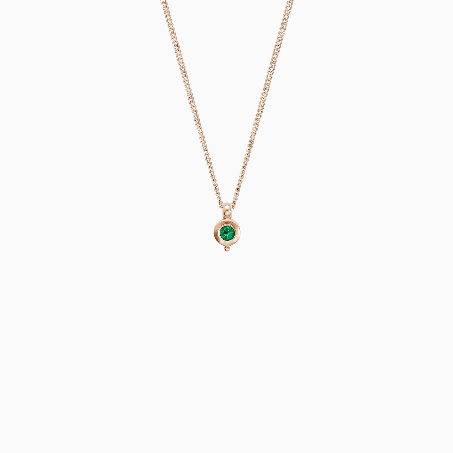 18ct Fairtrade rose gold round pendant 12mm  x 7mm with small round bead attached below on a 45cm fine curb chain. Set with a 4mm round emerald.