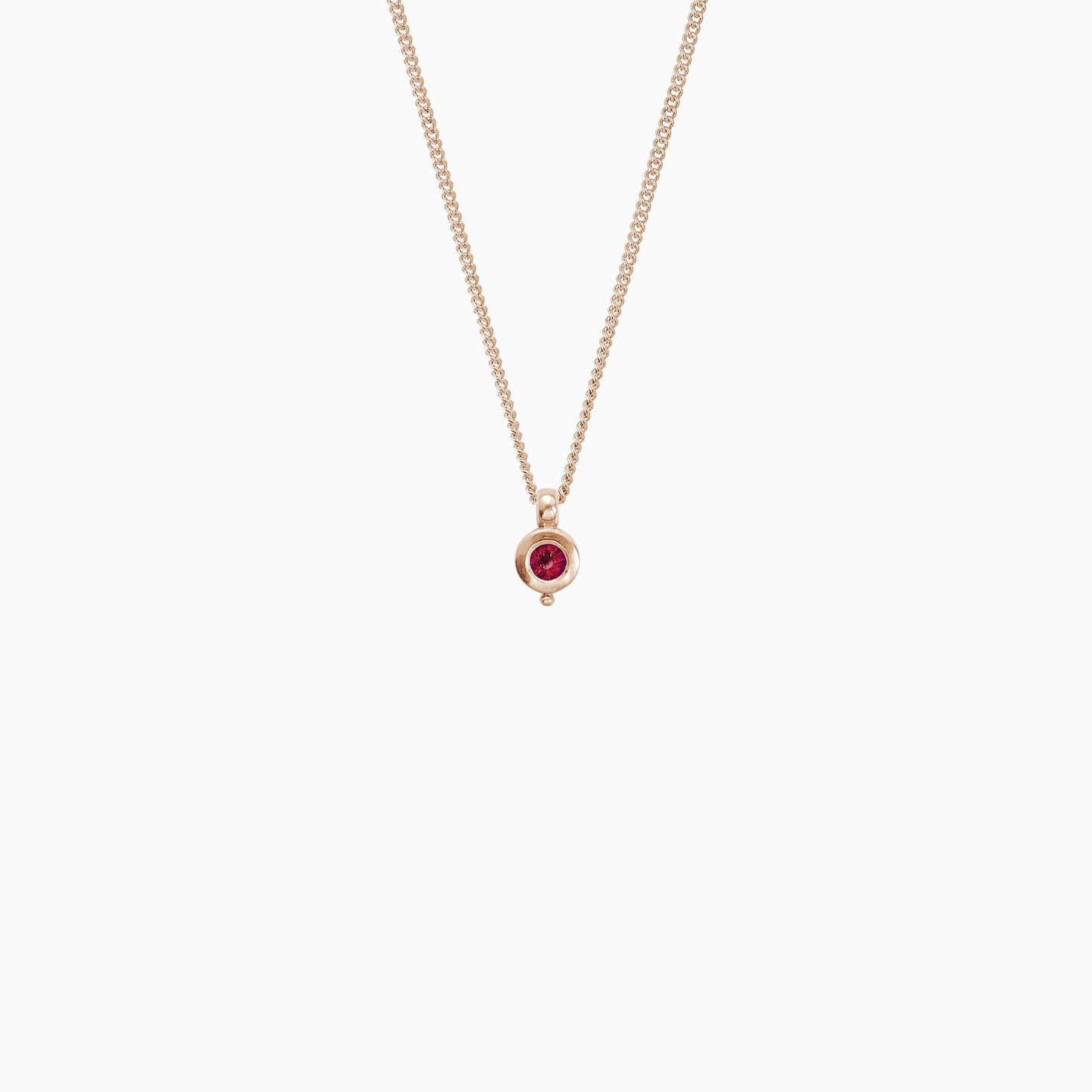 18ct Fairtrade rose gold round pendant 12mm  x 7mm with small round bead attached below on a 45cm fine curb chain. Set with a 4mm round ruby.