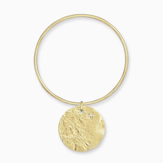 An 18ct Fairtrade yellow gold Textured, circular, flat disc charm freely moving on a round wire bangle. Charm 35mm. Bangle 63mm x 2mm.