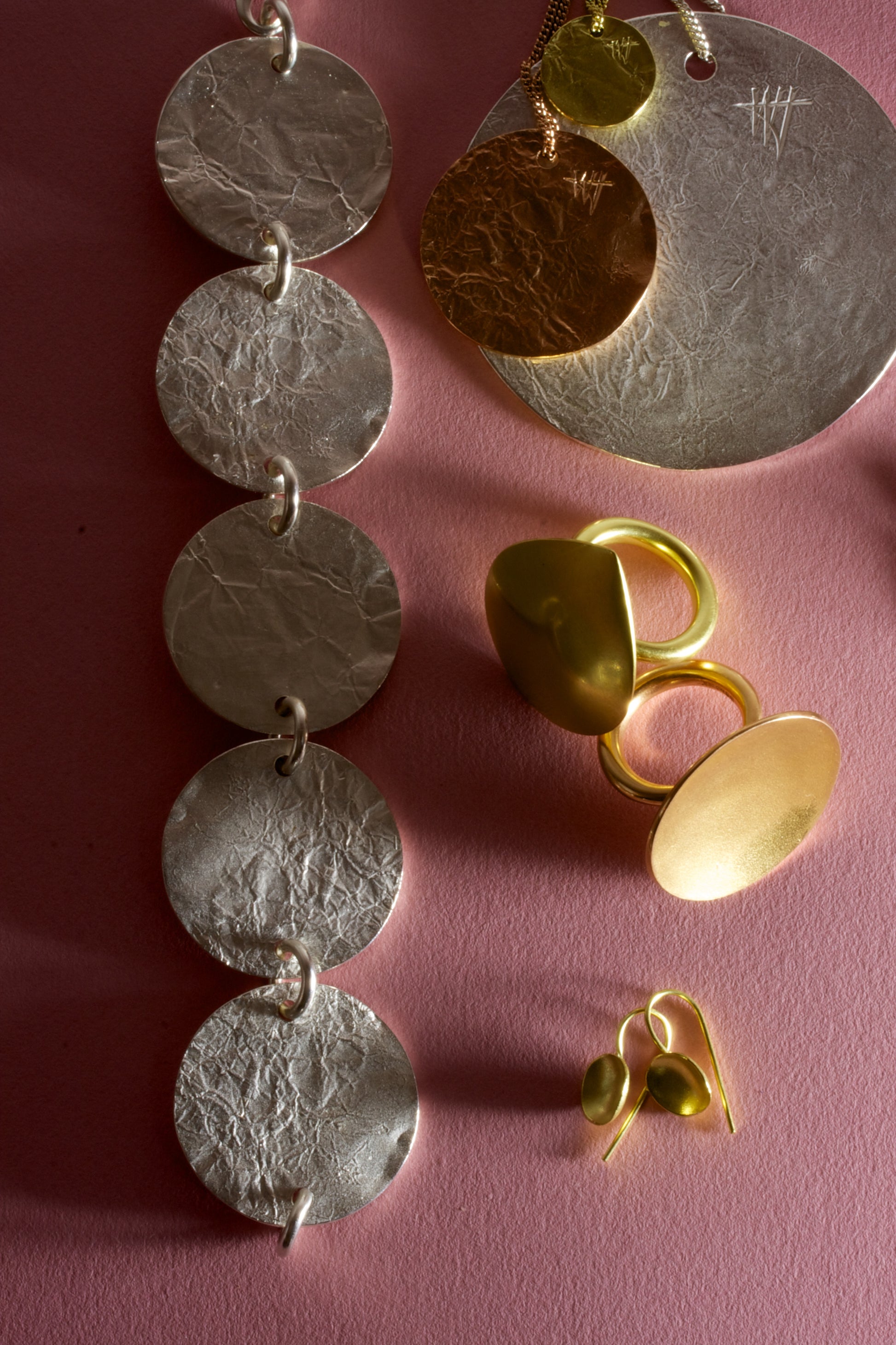 Still life photograph showing a group from our Cybele collection featuring discs of metal textured to give a crumpled effect. 