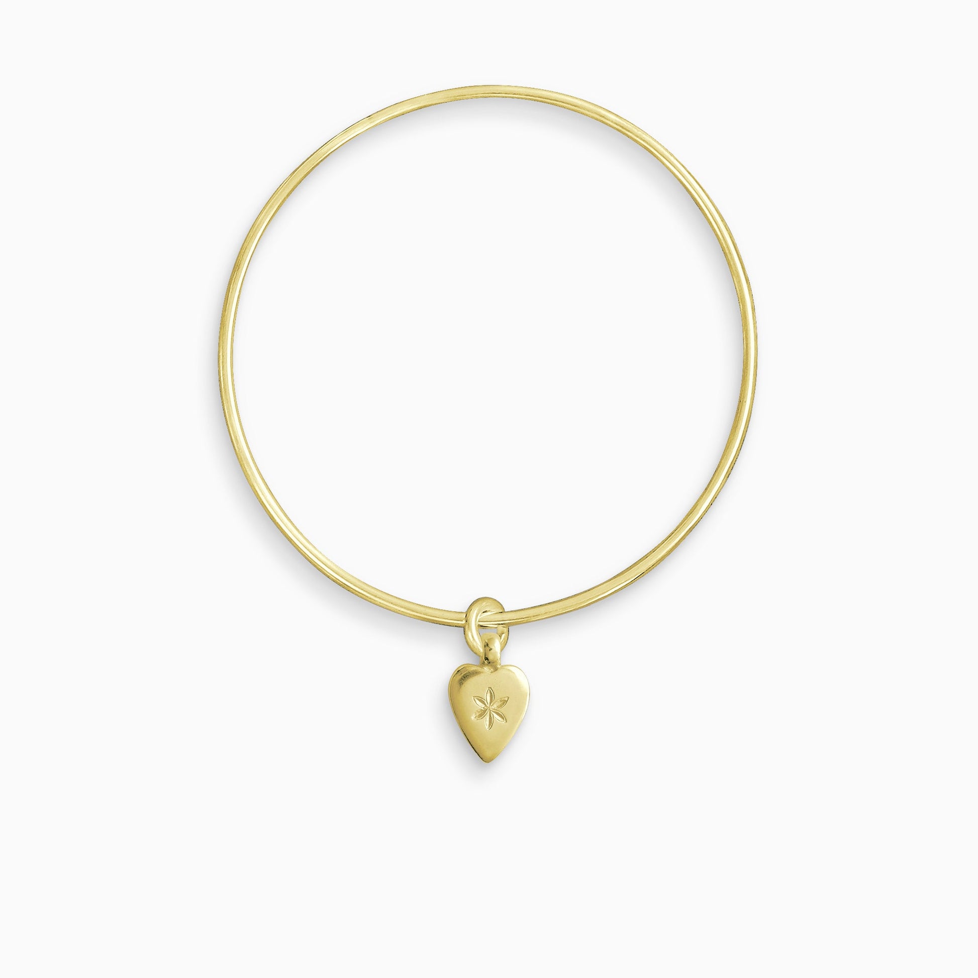 An 18ct Fairtrade yellow gold smooth heart shaped charm engraved with a 6 petal flower, freely moving on a round wire bangle. Charm 15mm x 8mm. Bangle 63mm inside diameter x 2mm round wire.