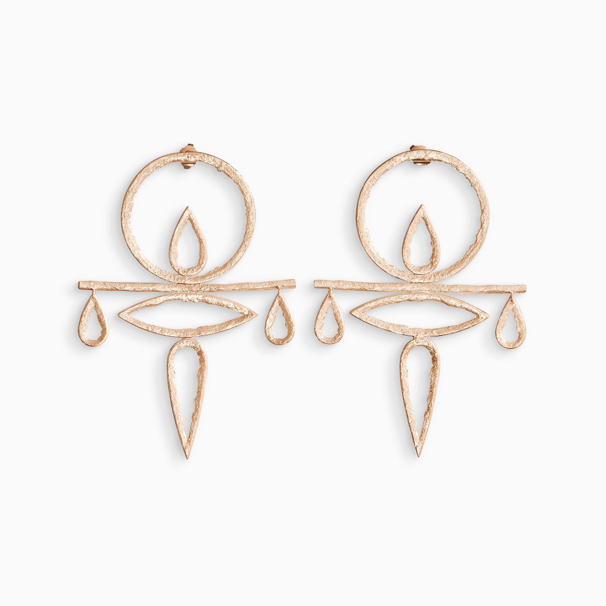 A large pair of 18ct Fairtrade rose gold drop stud earrings with a stud ear fitting. A large circle shape with a smaller teardrop shape inside connects to a fine horizontal bar. Below this is a large lozenge shape and a large teardrop shape. Hanging from the ends of the bar are small teardrop shapes. These open strongly textured shapes have smooth outside edges and fragmented inside edges. 85mm x 60mm.