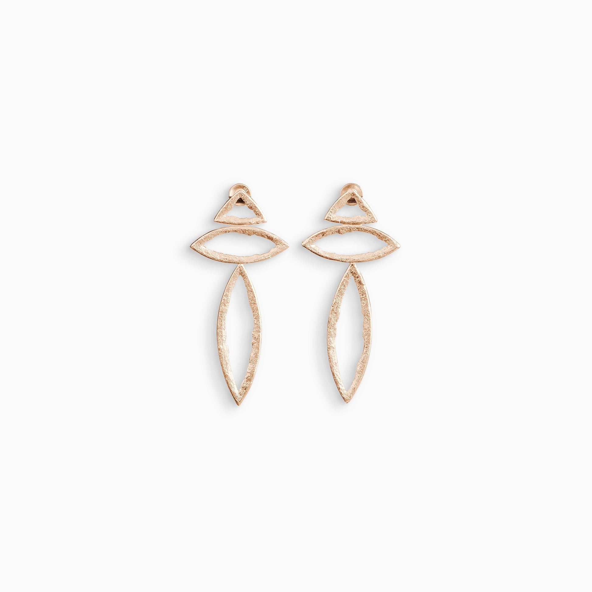 A pair of 18ct Fairtrade rose gold drop earrings with a stud ear fitting. A small triangular shape connects to a small lozenge shape to a larger lozenge shape to form a line. These open strongly textured shapes have smooth outside edges and fragmented inside edges. 46mm x 26mm.