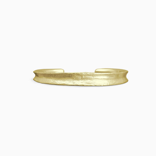 An 18ct Fairtrade yellow gold Cuff bangle fitting close to wrist. Concave and textured. Open ended to get on and off. Width 8mm. Inside oval diameter 58mm. 