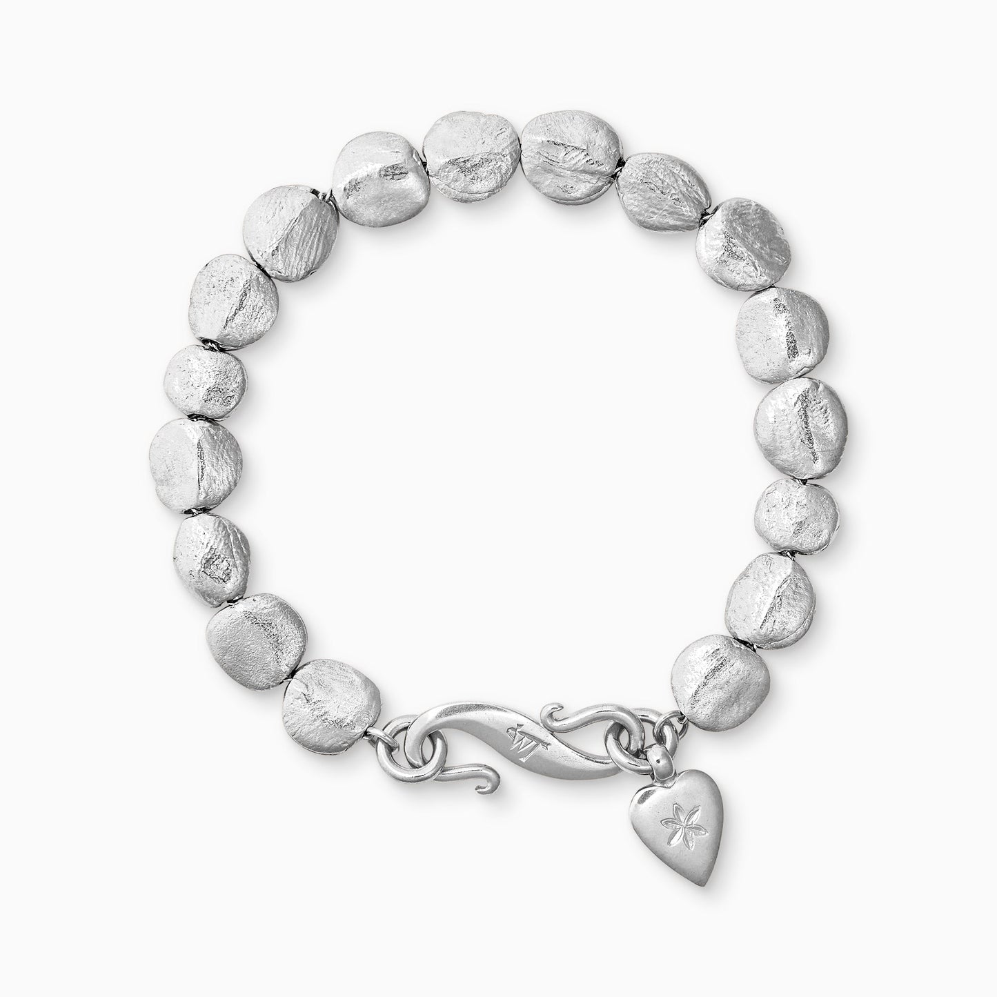 A recycled Silver bracelet of handmade textured beads with a smooth heart shaped charm engraved with a 6 petal flower and our signature ’S’ clasp. Bracelet length 210mm. Beads varying from approximately 7mm x 4mm to 10mm x 11mm