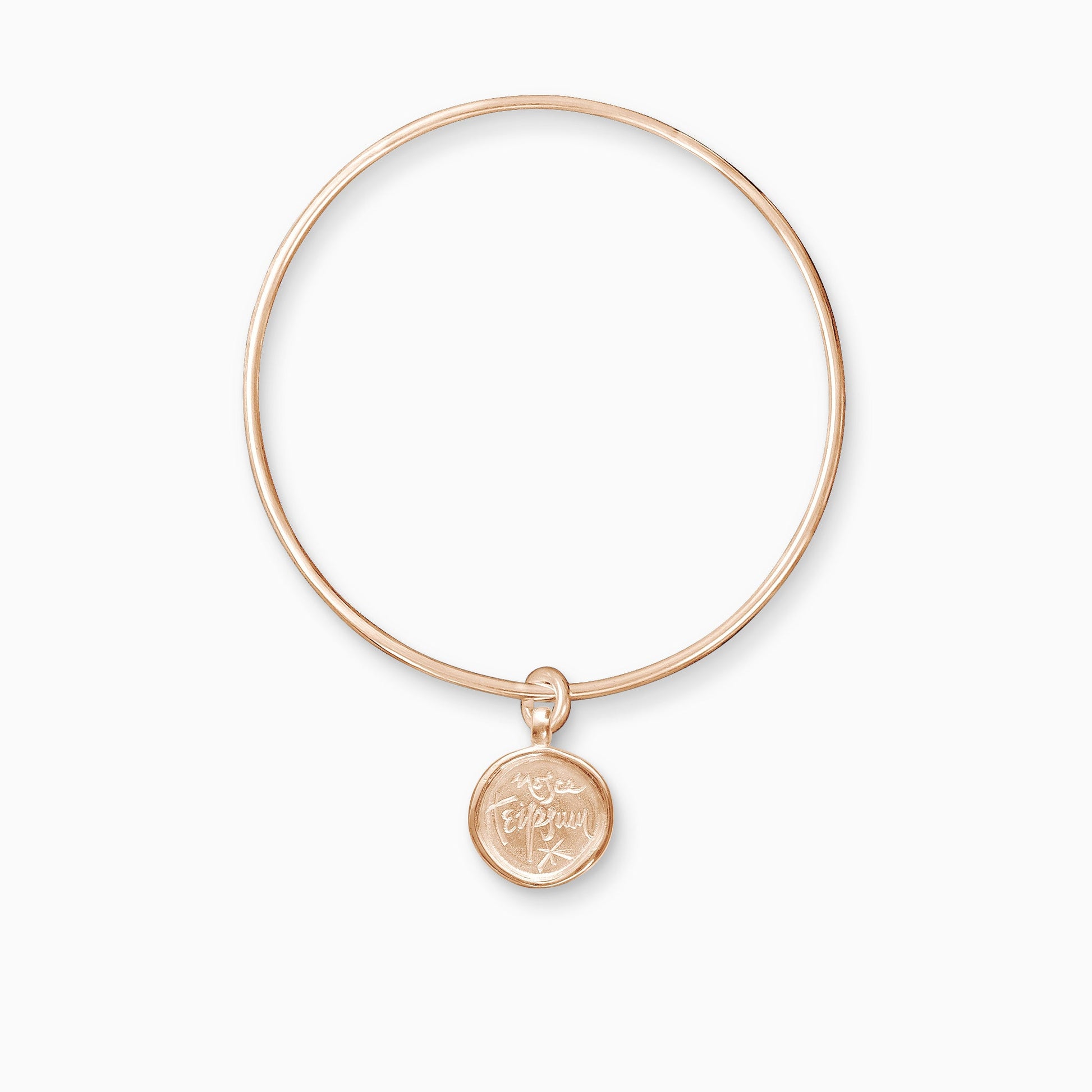 An 18ct Fairtrade rose gold round charm with a raised edge engraved with ‘Know Thyself’ freely moving on a round wire bangle.  Charm 15mm. Bangle 63mm inside diameter x 2mm round wire.