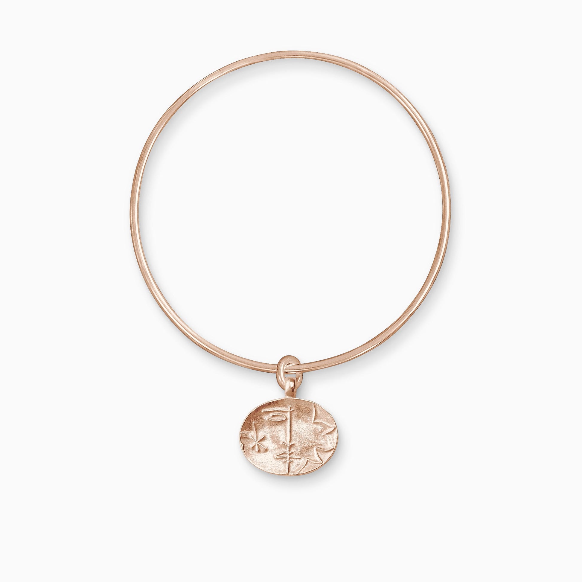 An 18ct Fairtrade rose gold oval shaped charm with raised image of a Sun on one side and a Moon on the other, freely moving on a round wire bangle.  Charm 16mm x 20mm. Bangle 63mm inside diameter x 2mm round wire.