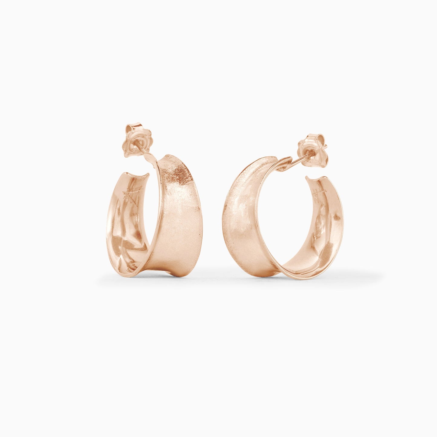 A pair of 18ct Fairtrade rose gold  round hoop earrings tapering in width from 11mm at the bottom to 6mm at the top. Gentle organic texture and form, concave outer surface. 24mm outside diameter with a stud fastening.