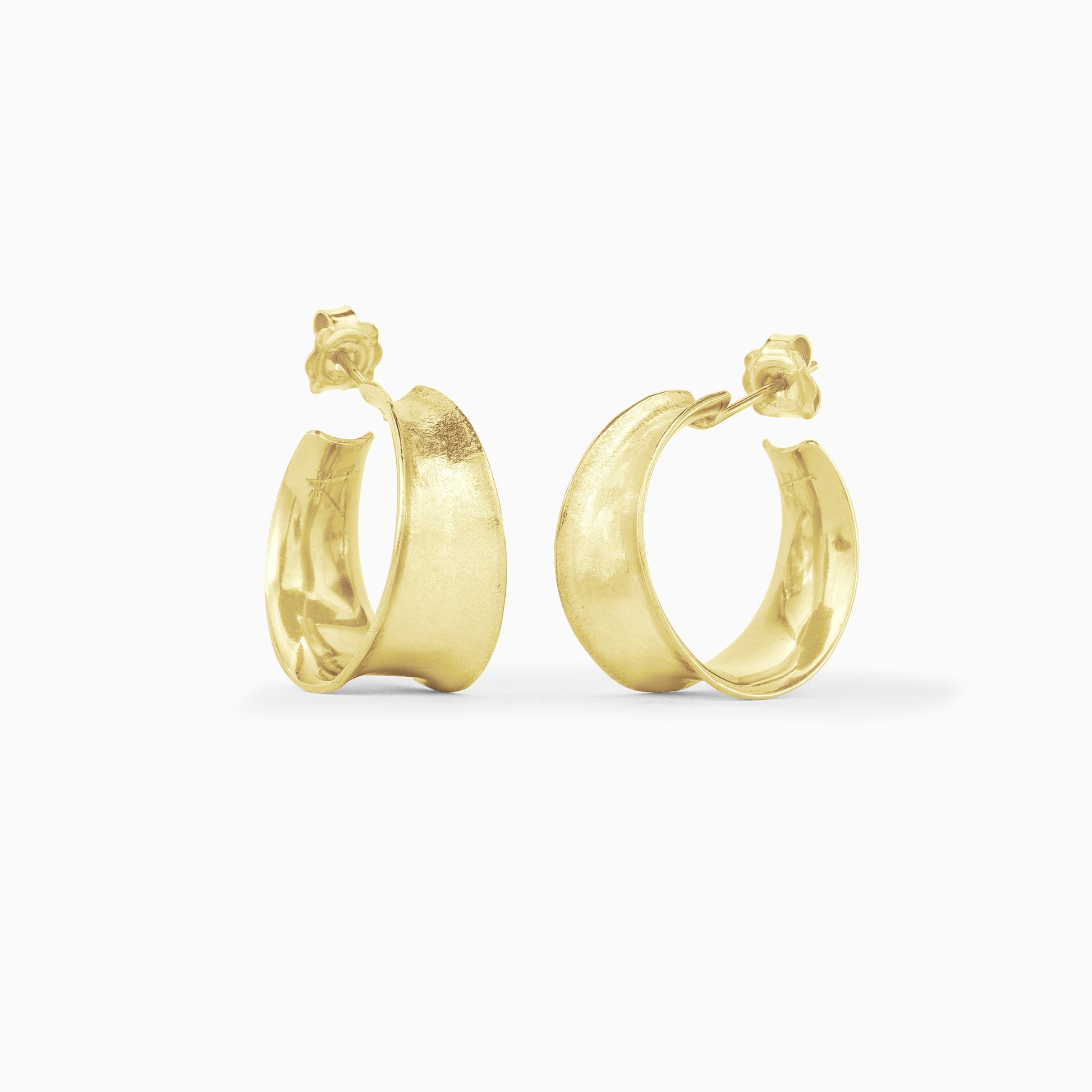 A pair of 18ct Fairtrade yellow gold round hoop earrings tapering in width from 11mm at the bottom to 6mm at the top. Gentle organic texture and form, concave outer surface. 24mm outside diameter with a stud fastening.
