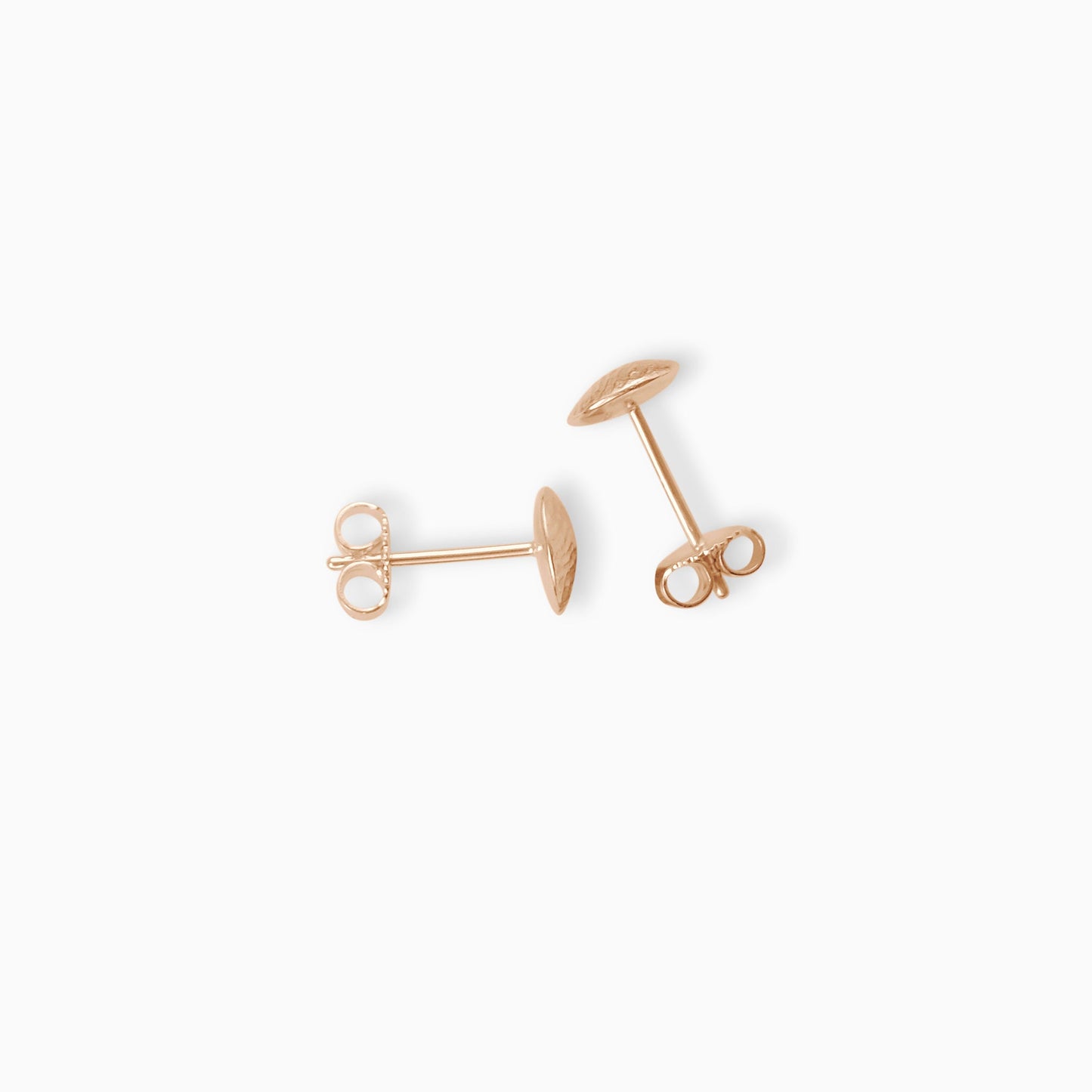 A pair of dainty 18ct Fairtrade rose gold disc shaped stud earrings. A soft pattern of diagonal lines across a slightly domed surface. 7mm diameter.
