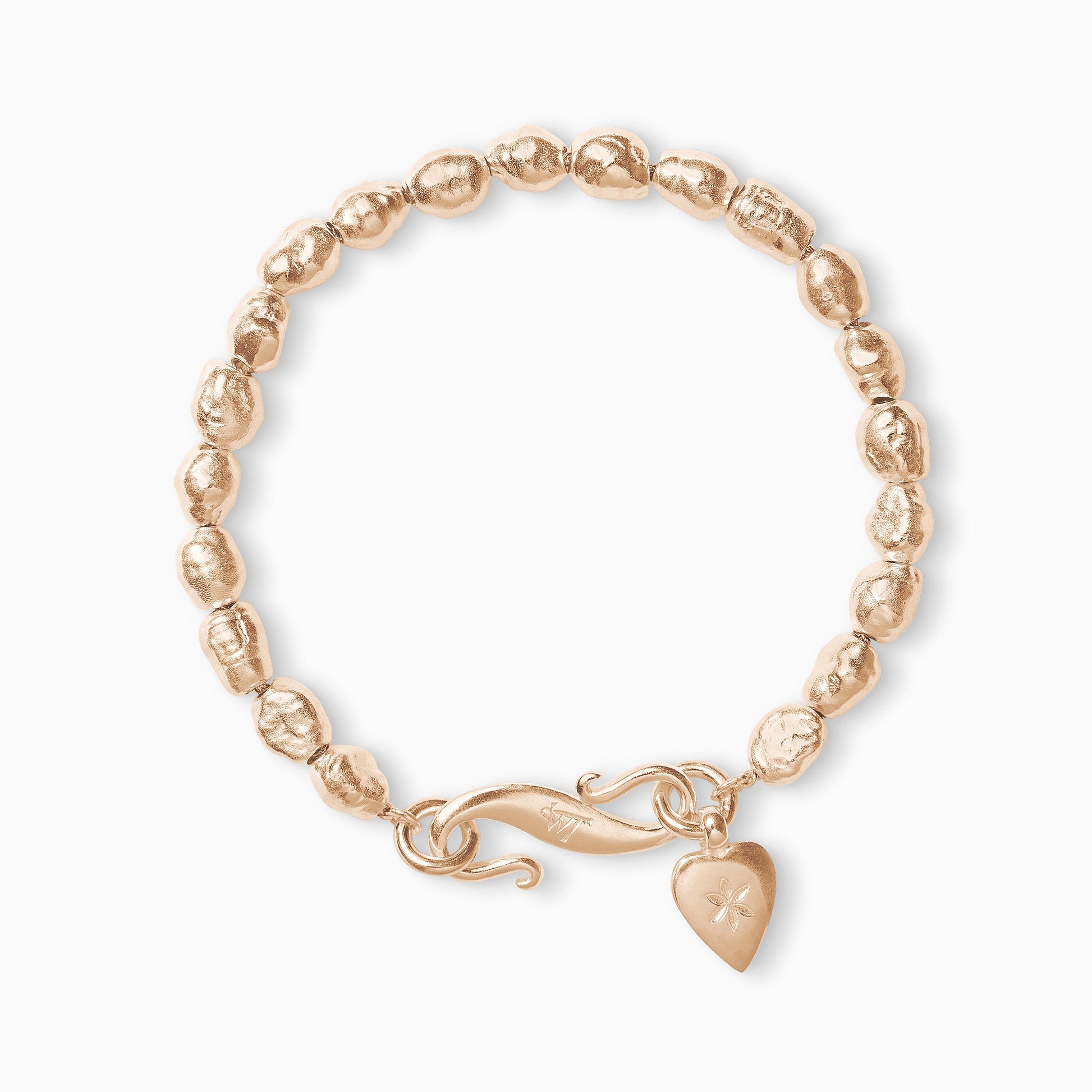 An 18ct Fairtrade rose gold bracelet of handmade irregular pearl shaped textured beads with a smooth heart shaped charm engraved with a 6 petal flower and our signature ’S’ clasp. Bracelet length 210mm. Beads varying approximately 8mm x 6mm.